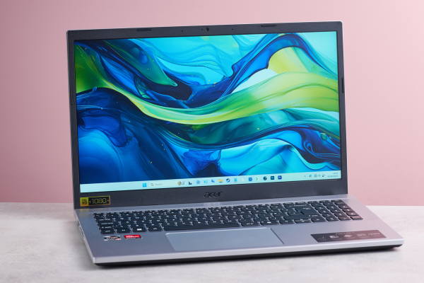 Three-quarter view of Acer Aspire Go 15 open on desk, with pink wall in background