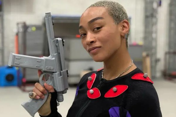 Intergalactic: The Heretic Prophet actor Tati Gabrielle smiles while brandishing prop weapon