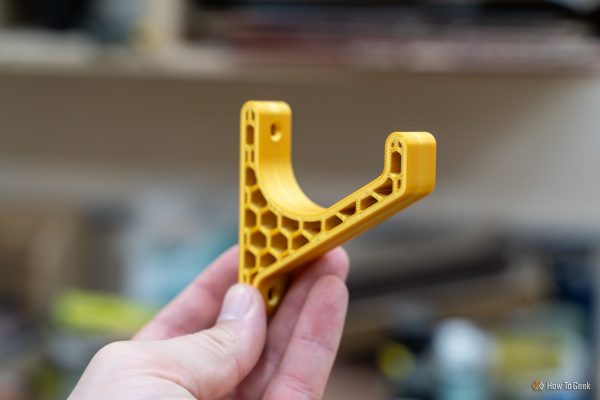 yellow 3d printed shop bracket with honeycomb infill held in hand