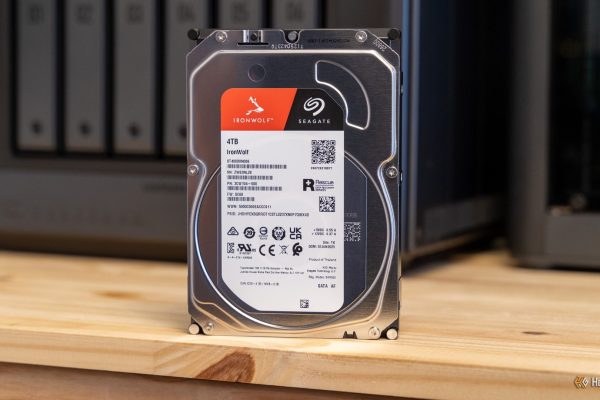 a seagate ironwolf 4tb hard drive standing upright on a desk in front of the ugreen idx6011 pro nas