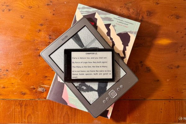 a xteink x3 ereader on top of a kindle 4 ereader on top of a paperback novel