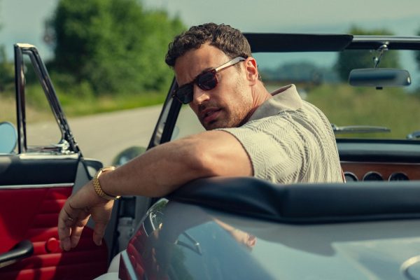 Theo James looks over his shoulder in a convertible